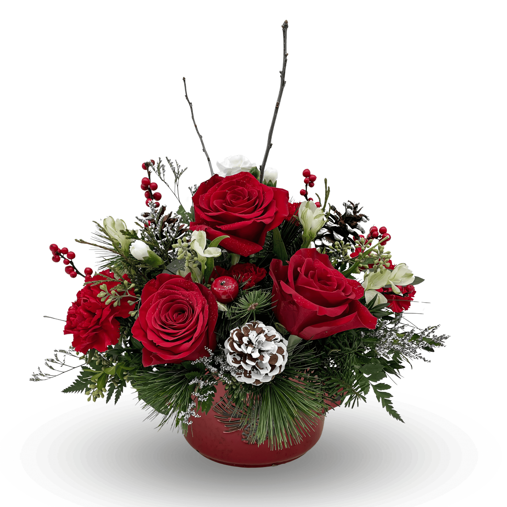 Crimson Noel Christmas floral arrangement featuring red roses, white alstroemeria, frosted pinecones, red berries, and greenery in a round red container.