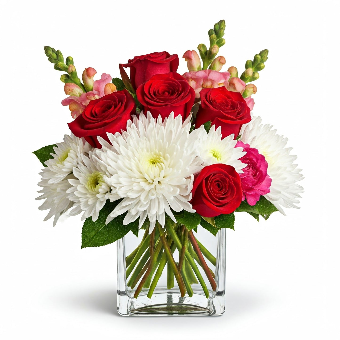 A lush Romantic Bliss flower arrangement in a square glass vase, featuring red roses, white chrysanthemums, and pink snapdragons, accented with subtle greenery. Perfect for Valentine's Day.