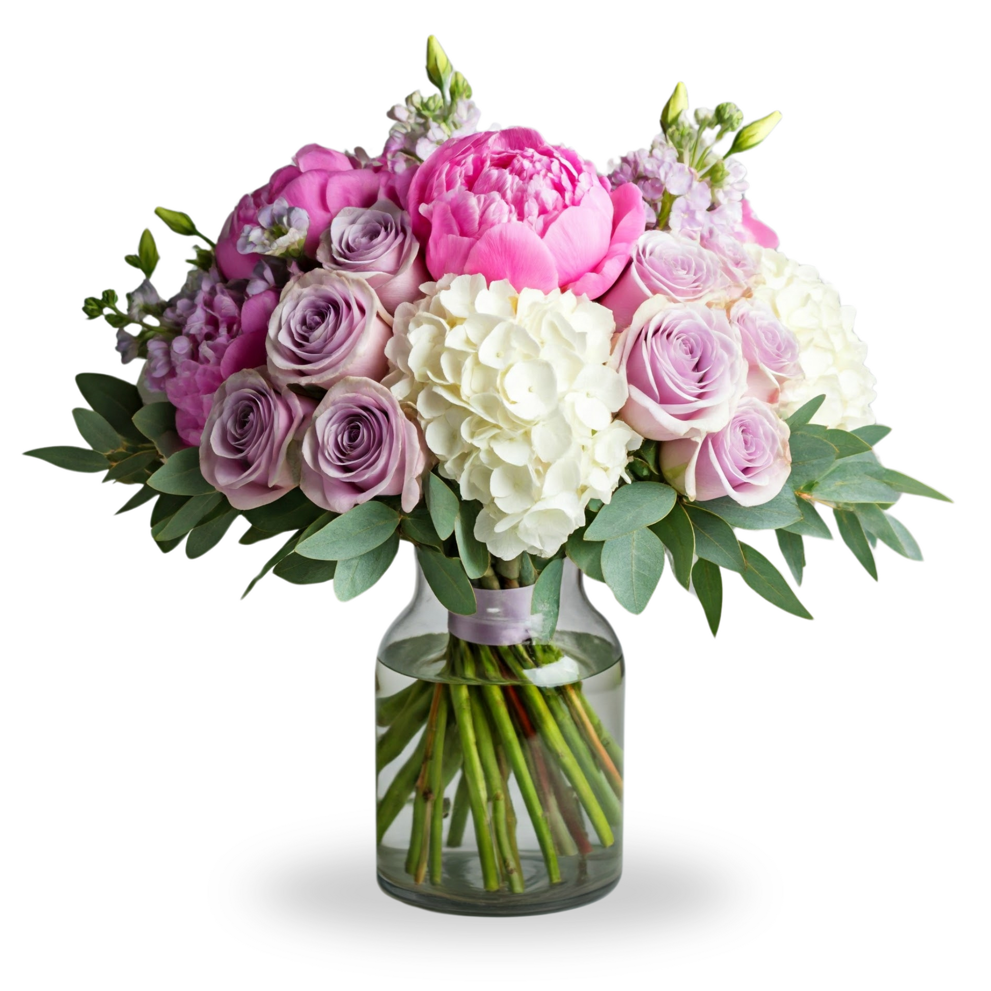 A romantic pastel bouquet in a clear glass vase featuring pink peonies, lavender roses, white hydrangeas, baby's breath, and lush greenery, perfect for expressing love.